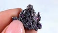 Woman hand holding shiny black Carborundum crystal (Moissanite or Silicon Carbide)