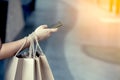 Woman hand holding shopping bags and using smartphone Royalty Free Stock Photo