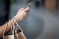 Woman hand holding shopping bags and using smartphone Royalty Free Stock Photo