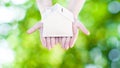 Woman hand holding small home model wooden with nature green bokeh abstract background. Family life and Business real estate Royalty Free Stock Photo