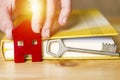 Woman hand holding small red house with key and book, sell house business concept Royalty Free Stock Photo