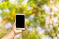 Woman hand holding smart phone blank screen outdoor with colorful of nature abstract bokeh background Royalty Free Stock Photo