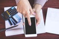 Woman hand holding smart phone calculating her monthly expenses with credit card,saving account book, deadline calendar concept fo Royalty Free Stock Photo