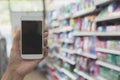 Woman hand holding smart phone in super market shopping