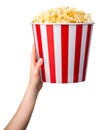 Woman hand holding striped bucket with popcorn isolated on white background Royalty Free Stock Photo