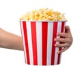 Woman hand holding striped bucket with popcorn isolated on white background Royalty Free Stock Photo