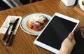 Woman hand holding tablet in coffee cafe, Modern working lifestyle in the city Royalty Free Stock Photo