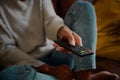 Closeup of young female hand holding remote control and changing channel at home watching television alone Royalty Free Stock Photo