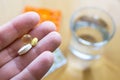 Woman hand holding three pills in the palm, close up. To get sick, take pills or undergo treatment