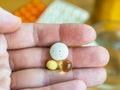 Woman hand holding three pills in the palm, close up. To get sick, take pills or undergo treatment