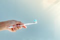 Woman hand holding toothbrush with toothpaste applied on. Closeup of white toothbrush with blue tooth paste Royalty Free Stock Photo