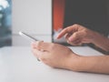 Woman hand holding and touching white mobile phone. She using application typing text message on smartphone Royalty Free Stock Photo