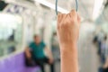 Woman hand holding the train rails while taking sky train.