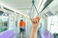 Woman hand holding the train rails while taking sky train.