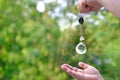 Woman hand holding and using glass ball crystal ball pendulum and using, female hands with crystal glass ball close-up on green Royalty Free Stock Photo