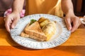 Woman hand holding white plate with omelet potato, tomatoes parsley and feta cheese and bread on wooden table Royalty Free Stock Photo