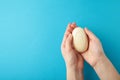 Woman hand holding a white soap bar on a blue background Royalty Free Stock Photo