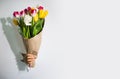Woman hand holding white tulips flowers through the hole in white paper . Royalty Free Stock Photo