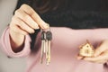 Woman hand holding wooden house model on gray background. Royalty Free Stock Photo