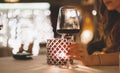 Woman hand holds a glass of wine in a restaurant with evening candle lighting