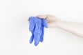 Woman hand holds a pair medical blue gloves against viruses and bacteria on a white background. Copy space