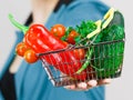 Woman hand holds shopping basket with vegetables Royalty Free Stock Photo