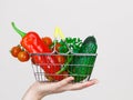 Woman hand holds shopping basket with vegetables Royalty Free Stock Photo