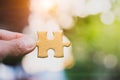 The woman hand holds a wooden jigsaw, the background is sunset, Royalty Free Stock Photo