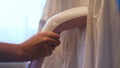 Woman hand ironing shirt with steam iron. Concept. Close up of a girl hands using steamer for ironing white shirt at Royalty Free Stock Photo