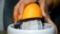 Woman hands juicing fresh orange fruit on juicer HD video. Prepa