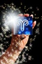 Woman hand keeping a blue card with zodiac symbol of Aries like astrology concept