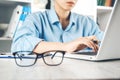 Woman hand keyboard with glasses on desk Royalty Free Stock Photo