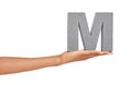 Woman, hand and letter M or font in studio for advertising, learning or teaching on mock up. Sign, alphabet or character