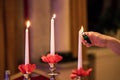 Woman hand lightning candles on Banquet with red table setting