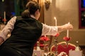 Woman lightning candles on Banquet with red table setting