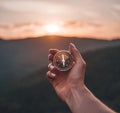 Woman hand with magnetic compass in mountains at sunrise, pov. Royalty Free Stock Photo