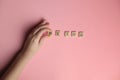 Woman hand making MeToo word with wooden alphabet on pink background, used for concept of sexual harrassment