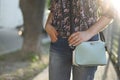 Woman hand with manicure and blue handbag