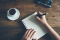 Woman hand notepad and camera on desk Royalty Free Stock Photo