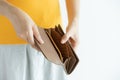 Woman hand open empty brown leather wallet , money in pocket on white background Royalty Free Stock Photo