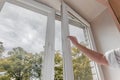 woman hand open pvc window with double glazing. Room ventilation concept