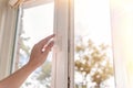 woman hand open white plastic window with sunny background Royalty Free Stock Photo