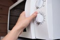 Woman hand opening microwave oven in order to prepare, heat food for lunch or dinner, kitchen elecrtric appliances using concept Royalty Free Stock Photo