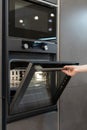 Woman hand opening new modern built-in oven on kitchen Royalty Free Stock Photo