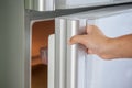 Woman hand opening refrigerator door Royalty Free Stock Photo