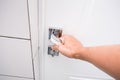 A woman hand opening a white wooden door with a chrome metal handle, security and protection of private life concept Royalty Free Stock Photo