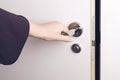 Woman hand opens a door to a dark and unknown room. Royalty Free Stock Photo