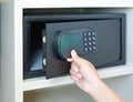 Woman hand opens a safe hidden in the wardrobe at the hotel Royalty Free Stock Photo