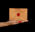 Woman hand palm shows old envelope over black Royalty Free Stock Photo