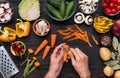 Woman hand peeling orange carrot with peeler